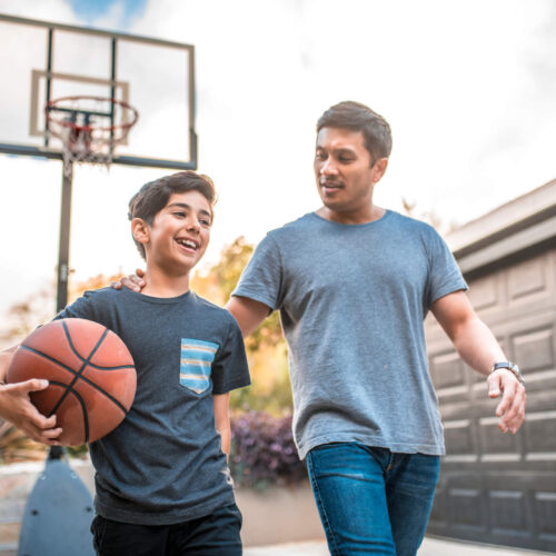 dad and son playing basketball