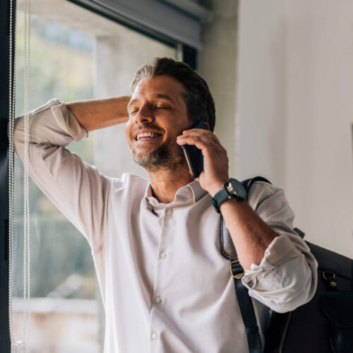 Hombre en el teléfono sonriendo porque recibió una liberación de embargo del IRS